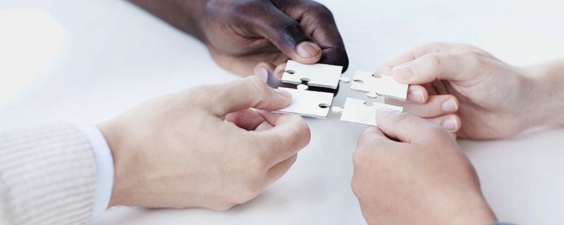 Hands putting puzzle together